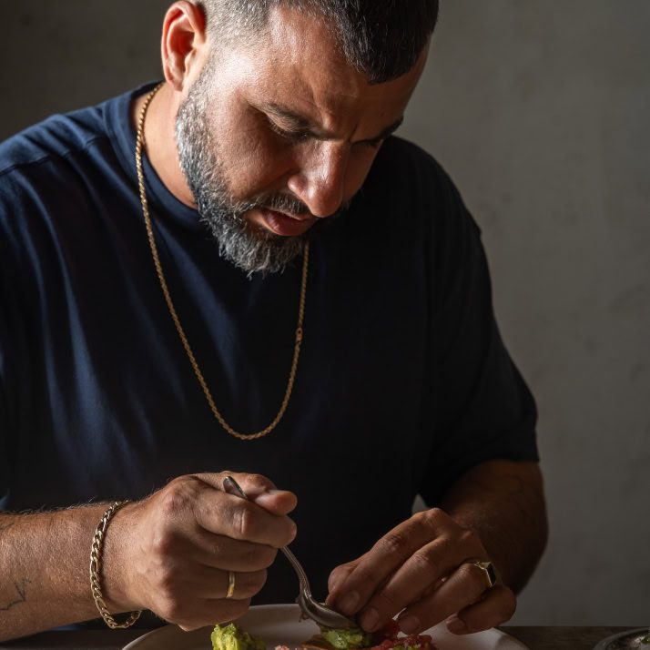 גבר אוכלים טרפלס שוקולד באילסר עם חיוך.
